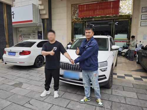 陈杰（右）正在与客户成交车辆