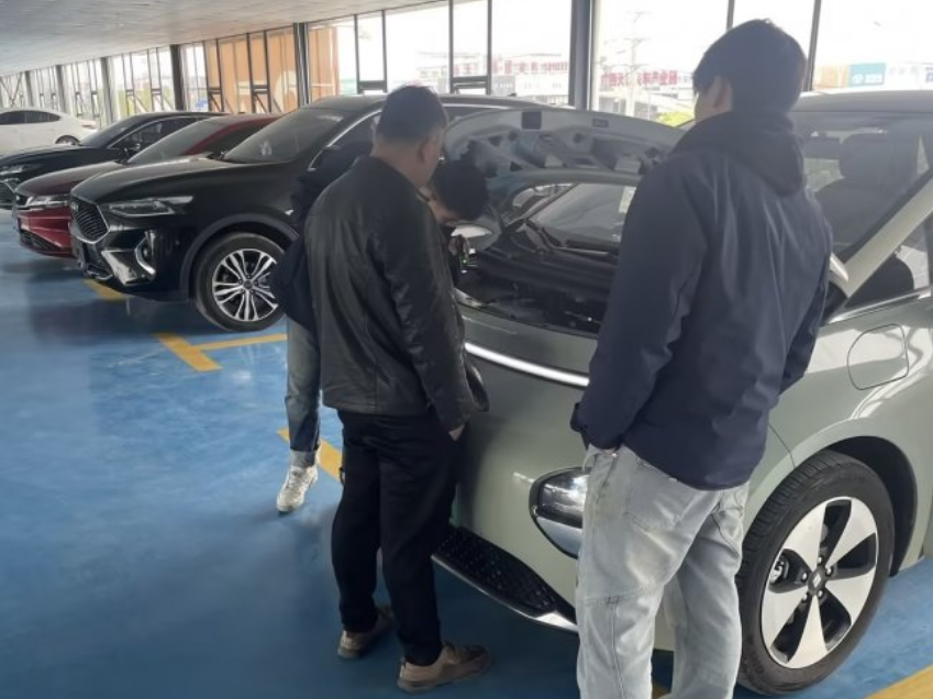 梁国伟（右）正在带客户看车